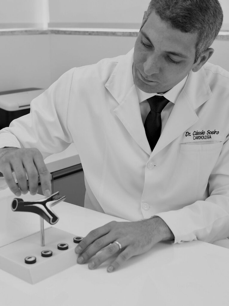 Foto do Dr. Cássio Soeiro, cardiologista e especialista em ecocardiograma, sorrindo na fachada da Clínica Pulsarti