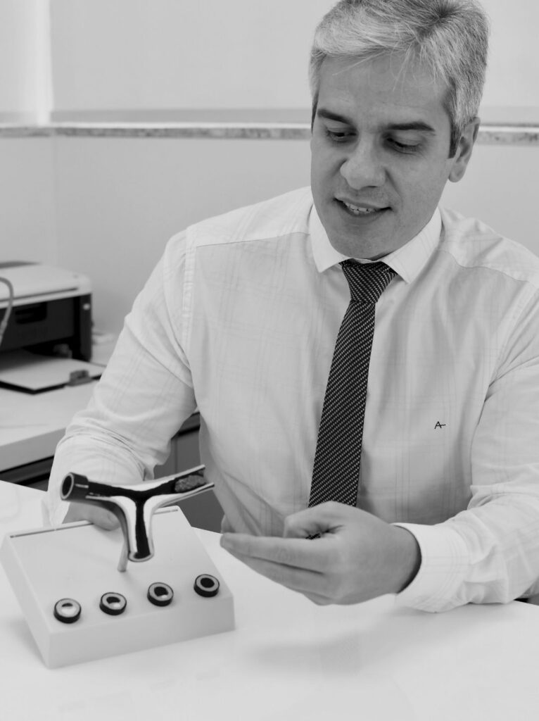 Foto do Dr. Matheus Marques, cardiologista e especialista em ecocardiograma, sorrindo na fachada da Clínica Pulsarti